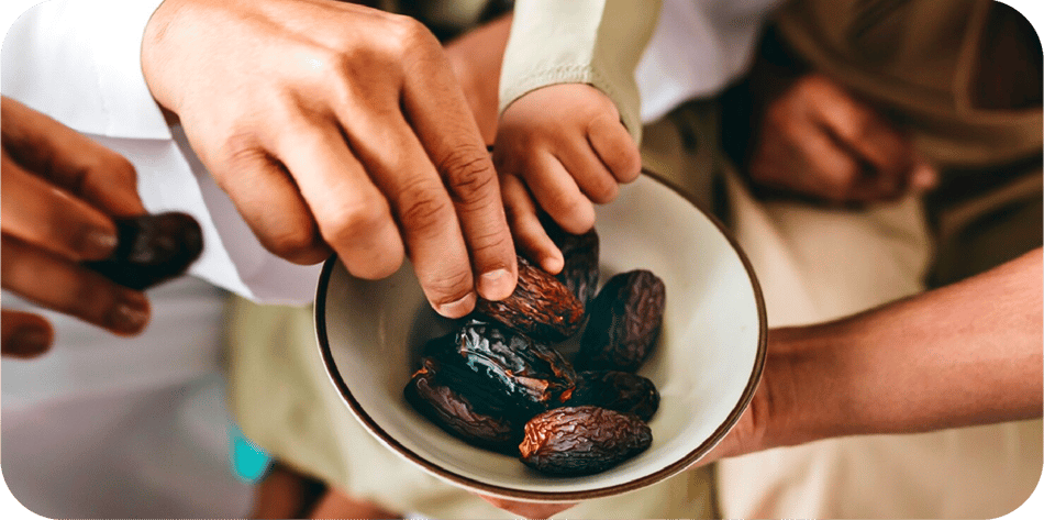 Hands reaching for a bowl of dates